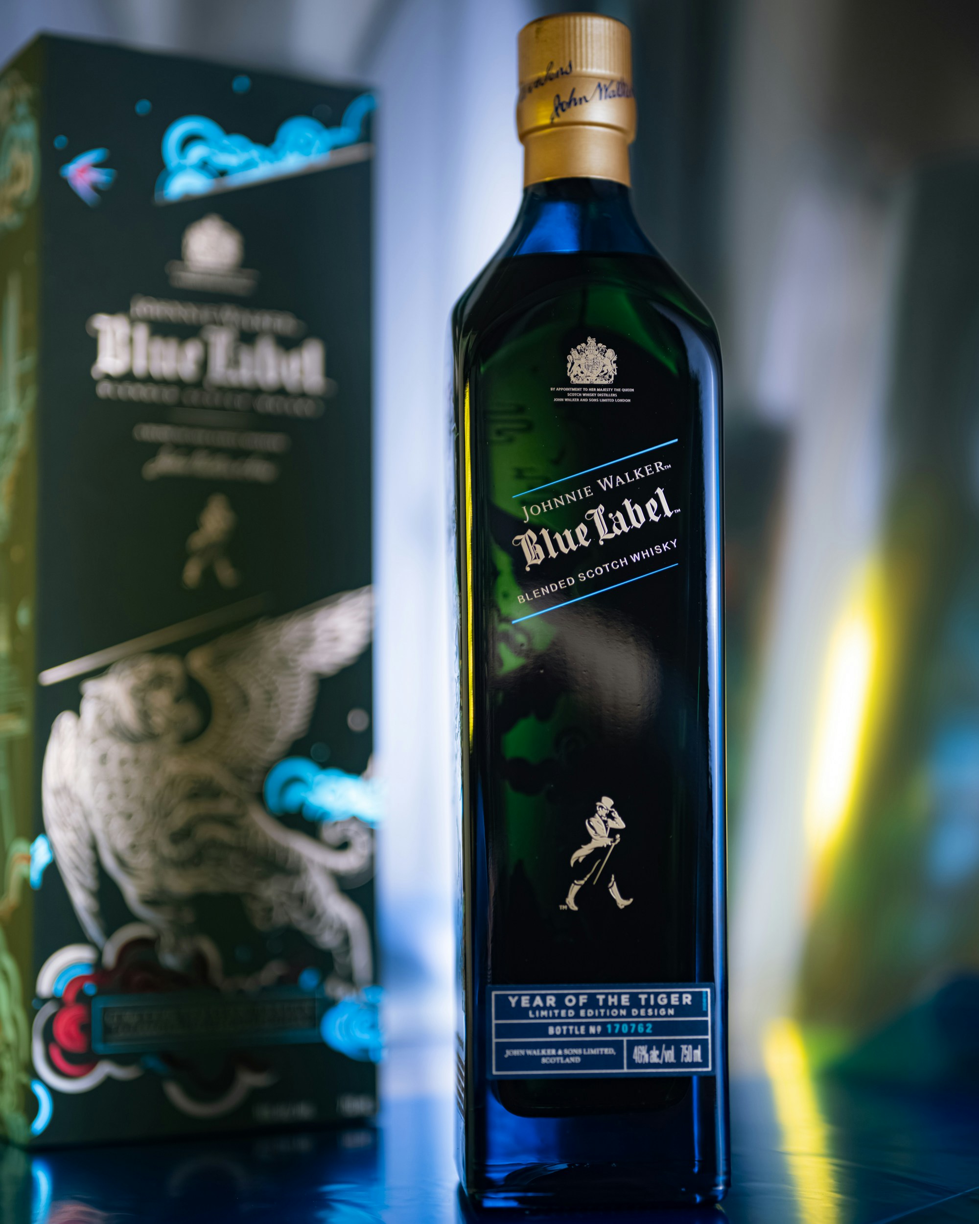 A bottle of blue label on a table next to a box photo – Free Alcohol ...