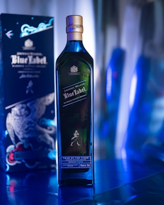 a bottle of blue label on a table next to a box