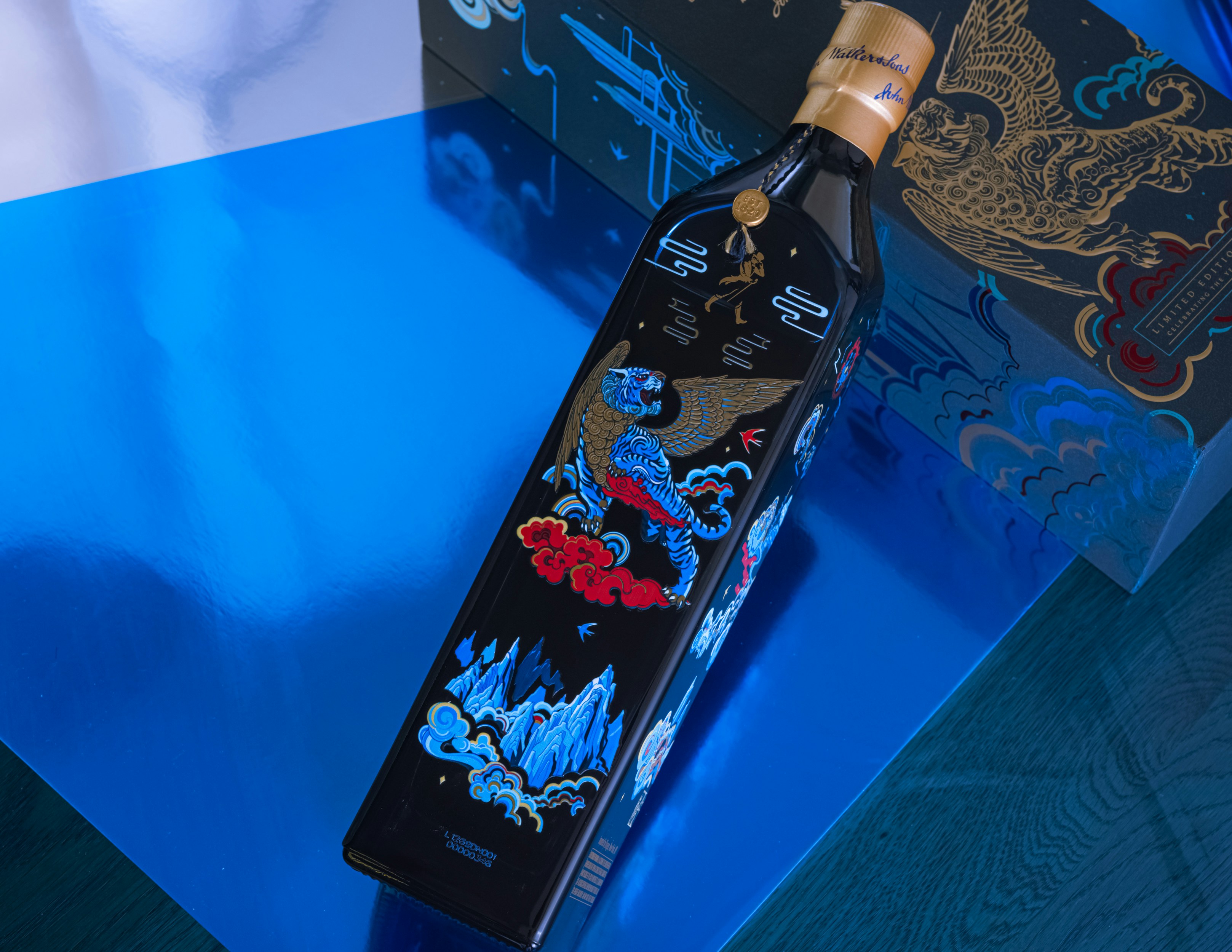 a bottle of wine sitting on top of a blue table