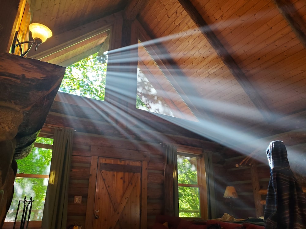 a woman standing in front of a window in a cabin