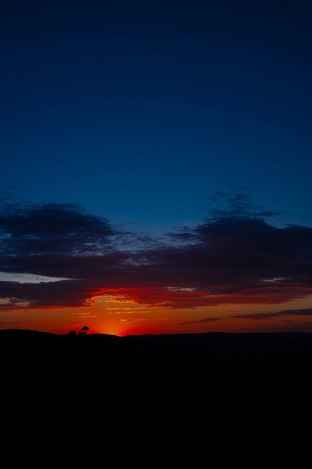 the sun is setting over the horizon of a field