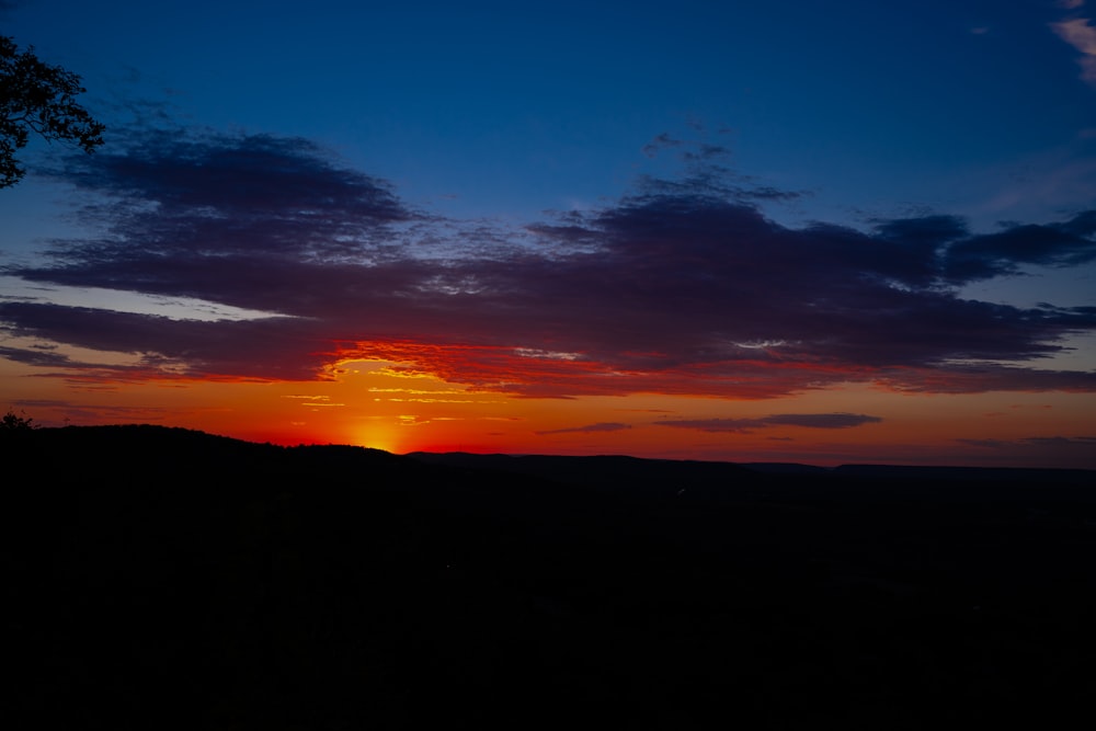 the sun is setting over a mountain range