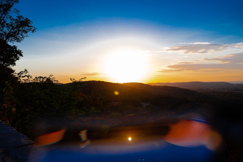 the sun is setting over a mountain range