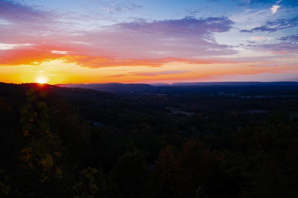 the sun is setting over the mountains in the distance