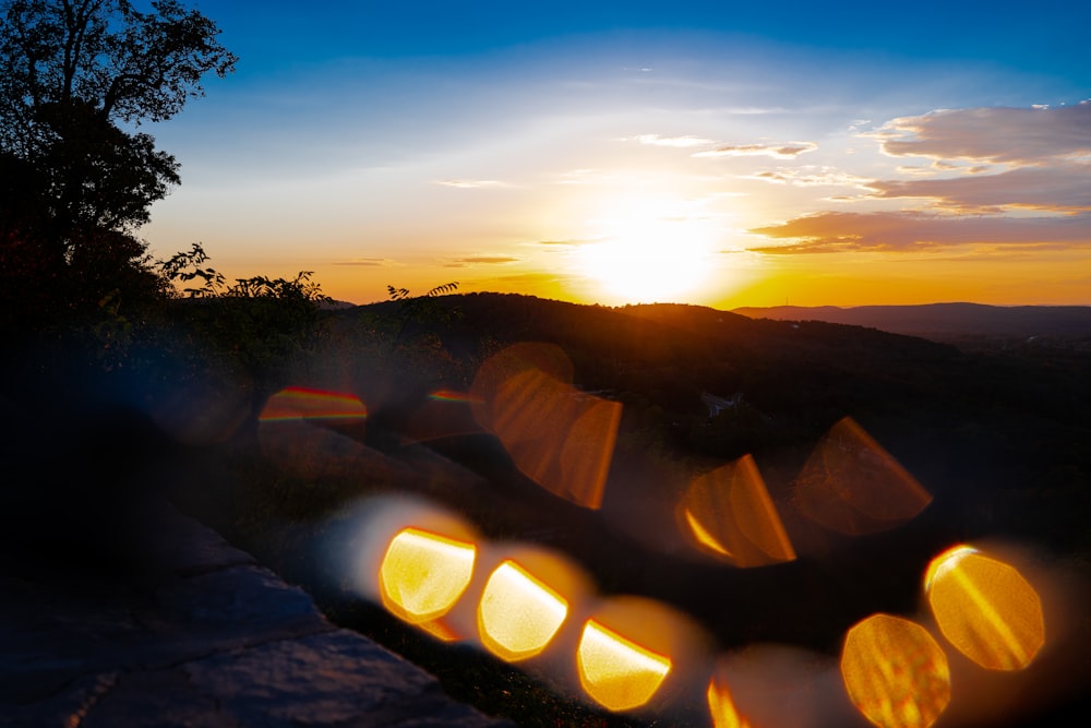 the sun is setting over the mountains and trees