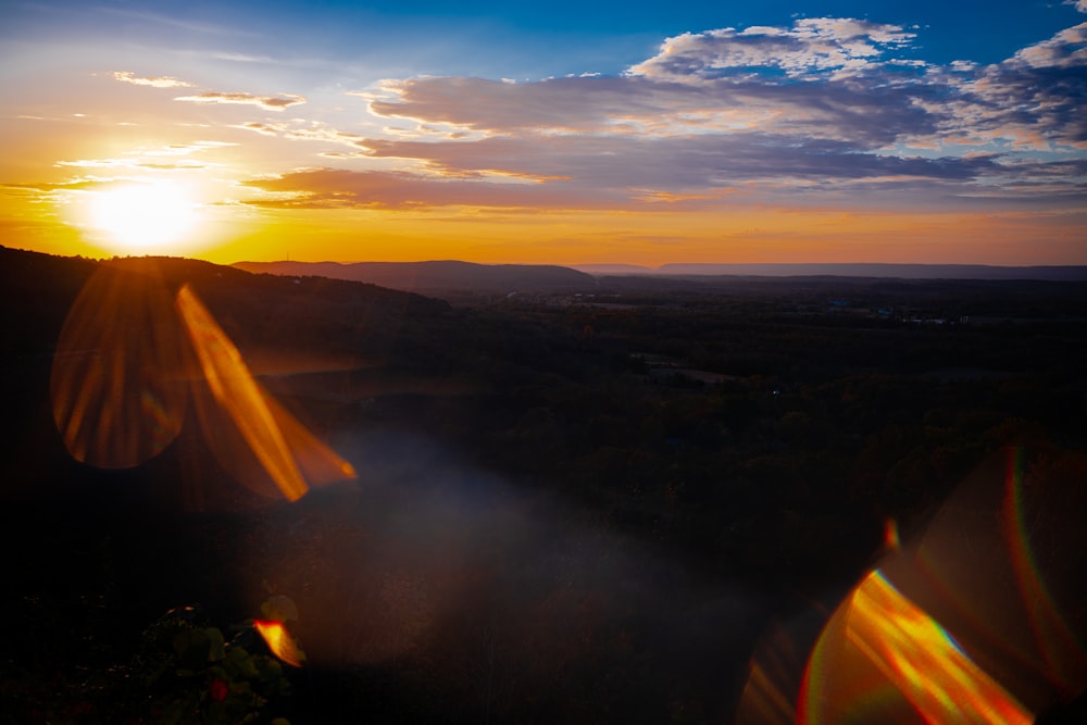 the sun is setting over a mountain range