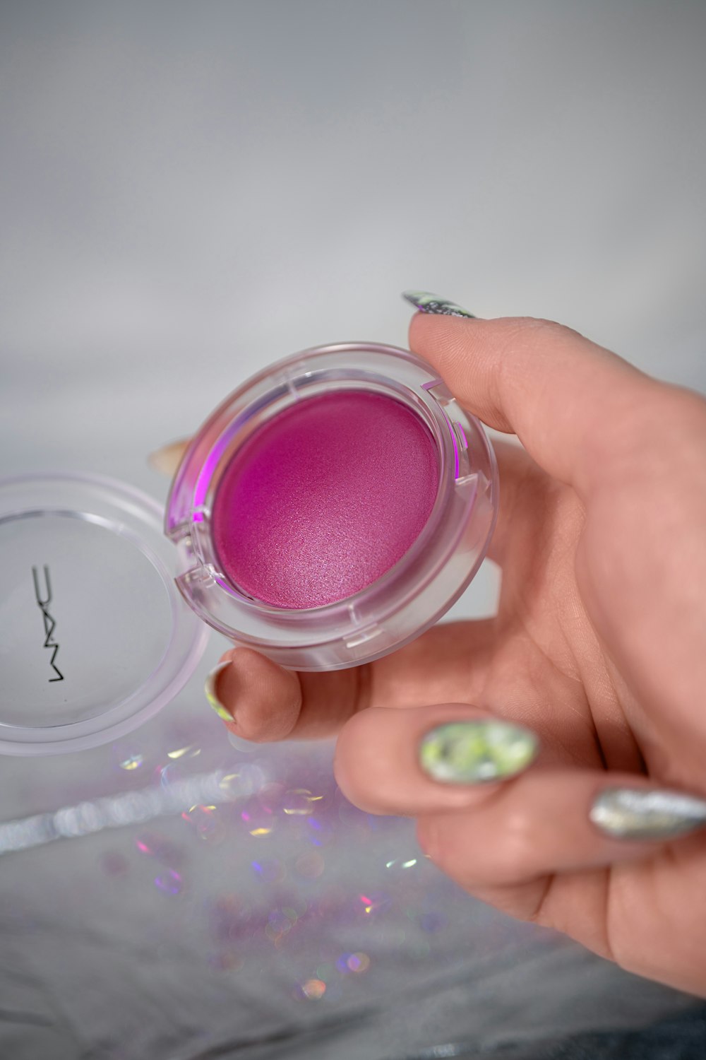 a person holding a pink powder in their hand