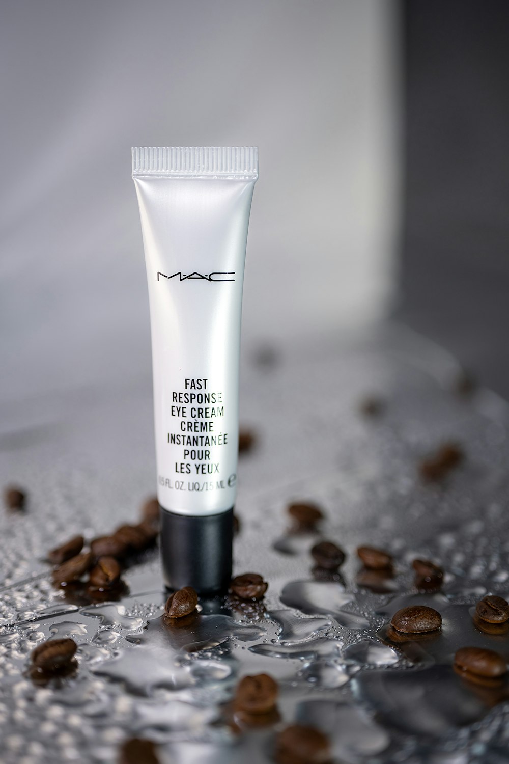 a tube of eye cream sitting on top of coffee beans