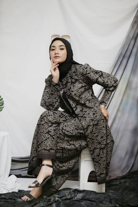 a woman sitting on a chair in a black dress