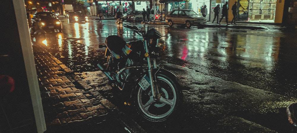 a motorcycle parked on the side of a wet street