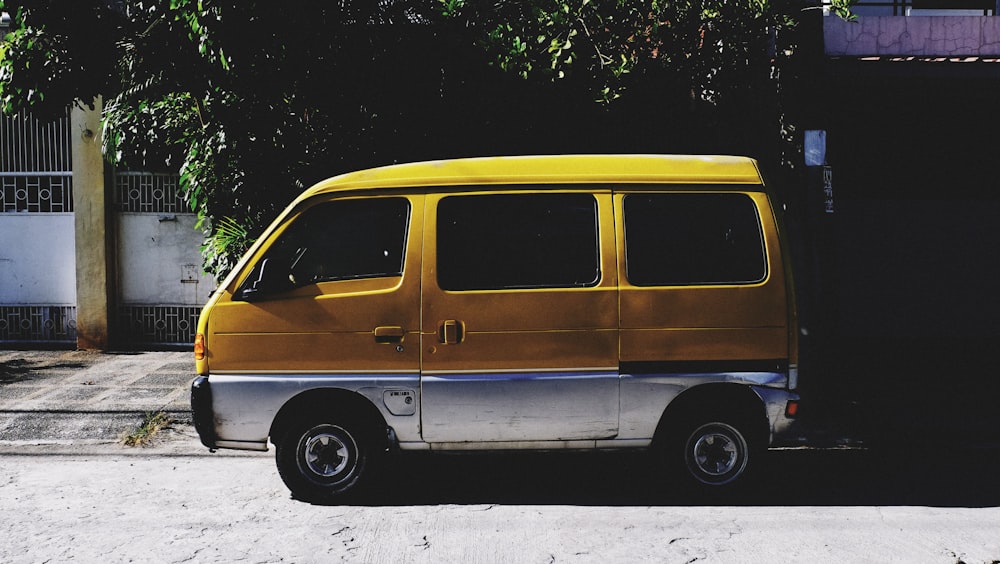 a small yellow van parked on the side of a road