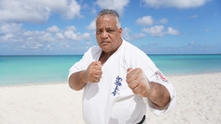 a man standing on a beach giving a thumbs up