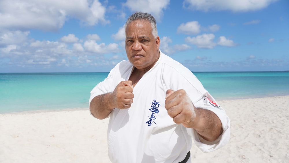 a man standing on a beach giving a thumbs up