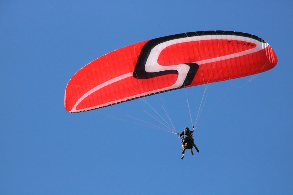 a person is parasailing in the blue sky