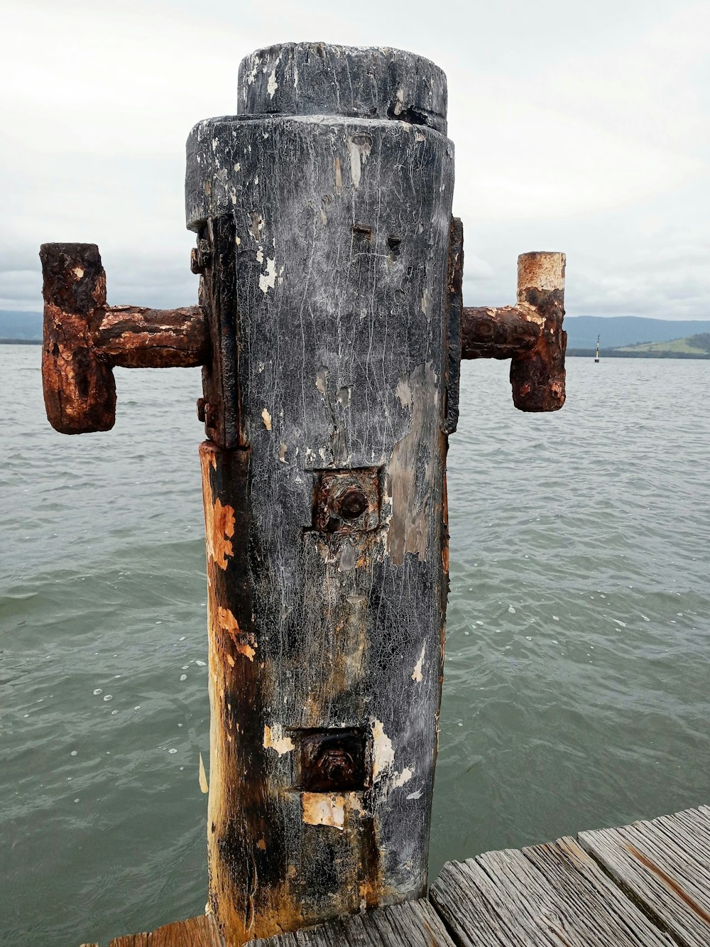 a rusted metal object sitting on top of a wooden pier