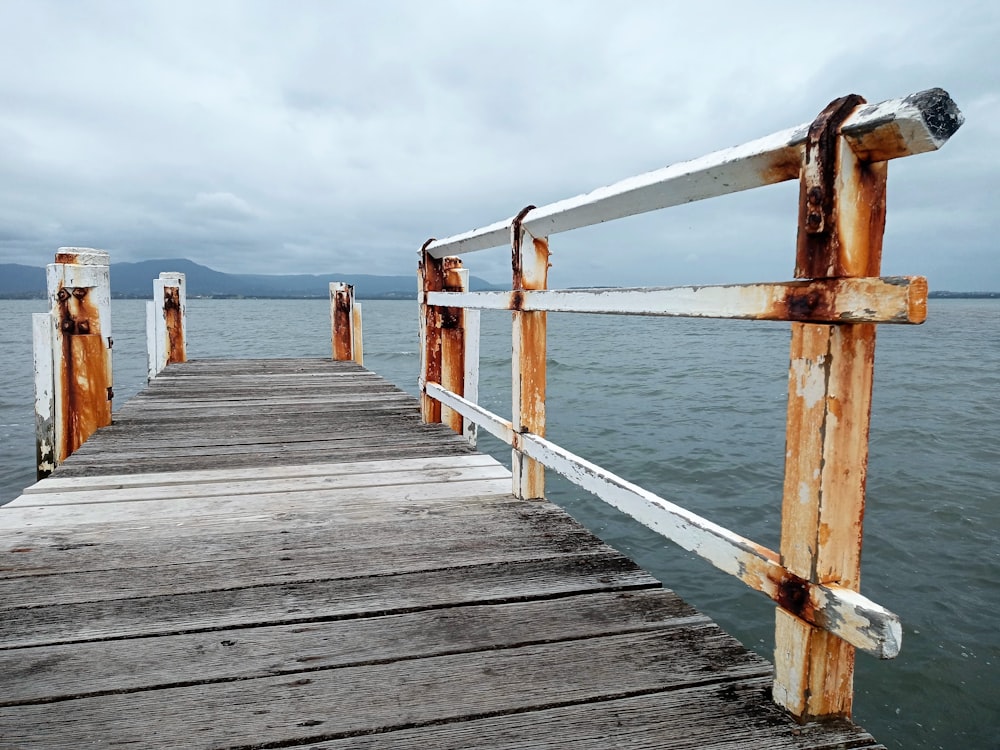 a wooden dock with metal railings extending out into the water