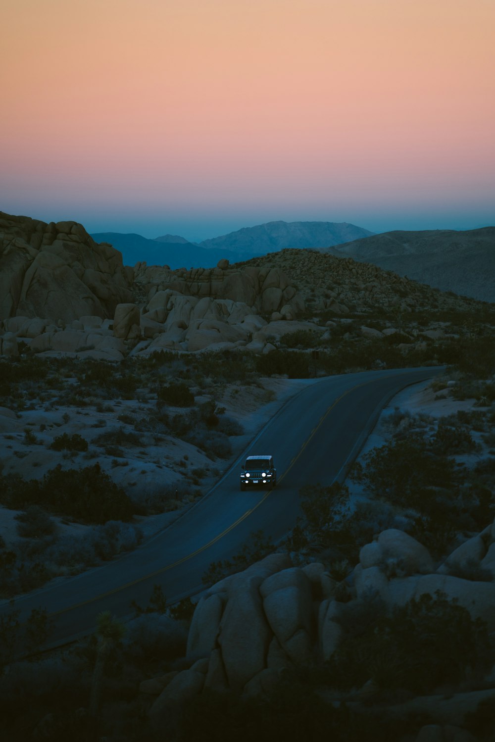 a car driving down a road in the desert