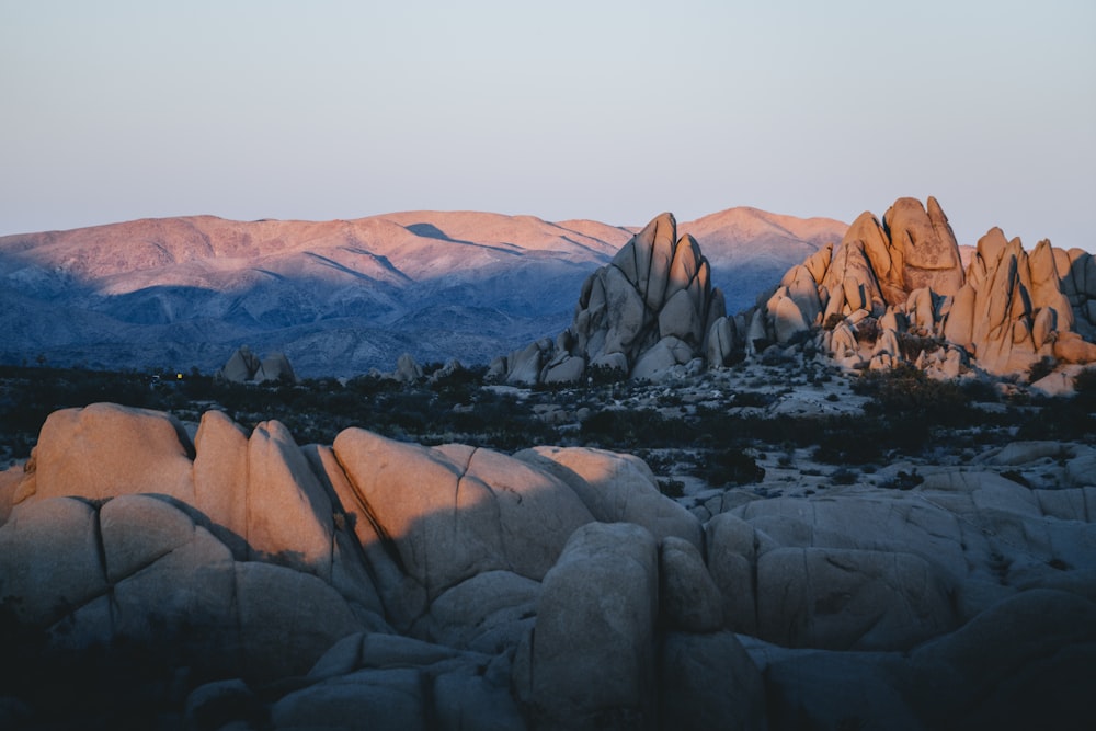 a view of a mountain range with rocks in the foreground