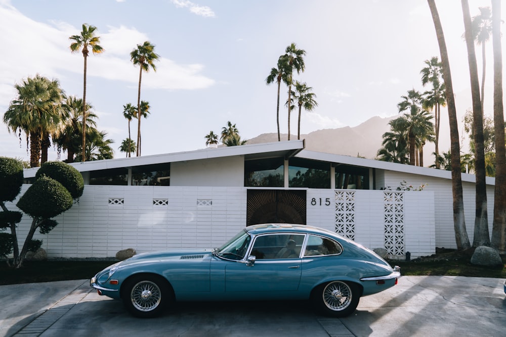 a blue car parked in front of a house