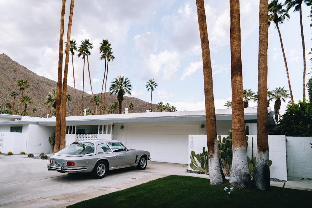 a car parked in front of a house with palm trees