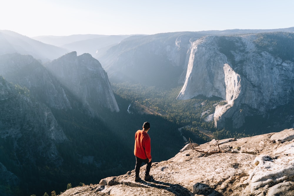 a man standing on top of a mountain overlooking a valley