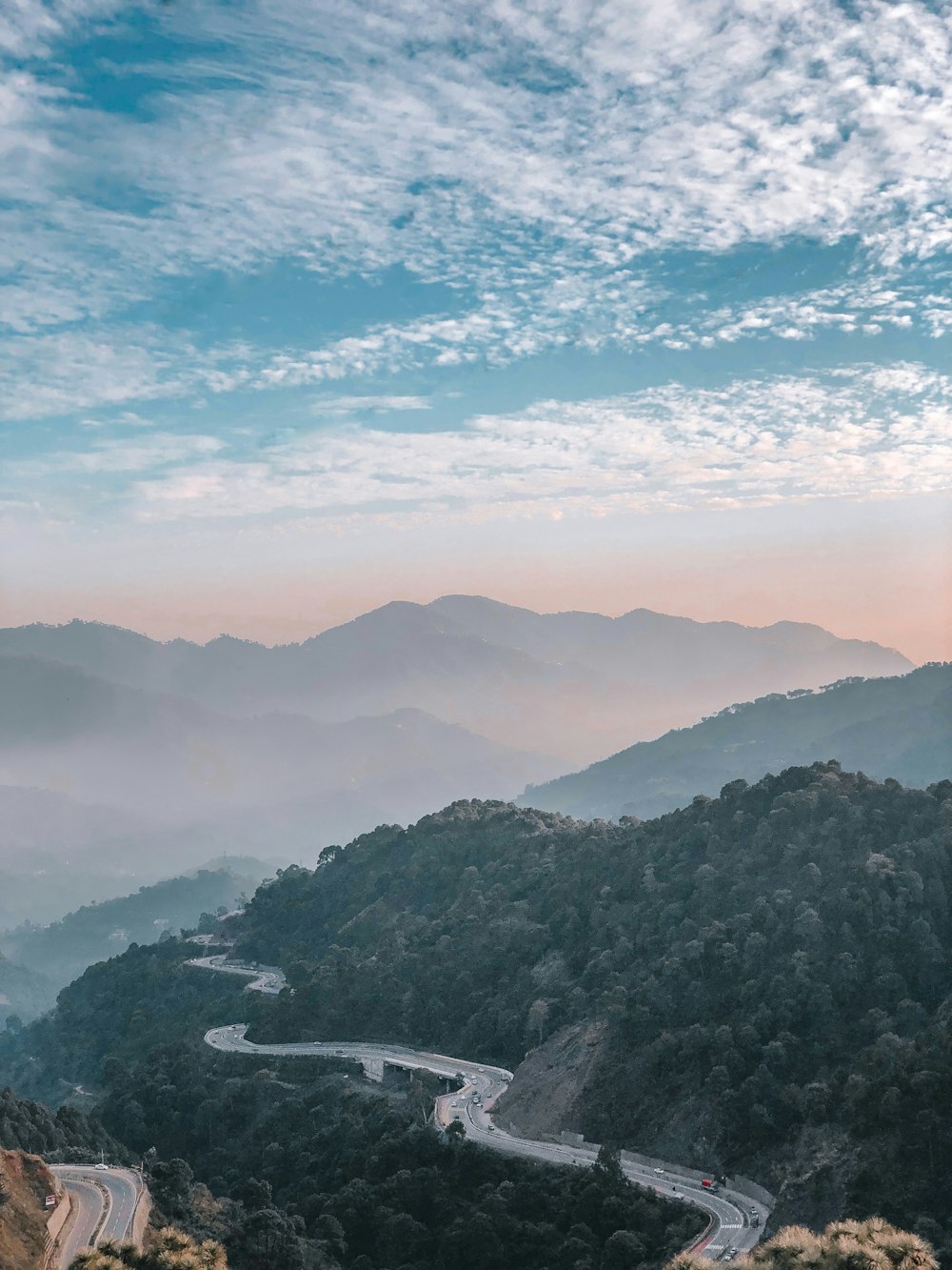 a scenic view of a winding road in the mountains