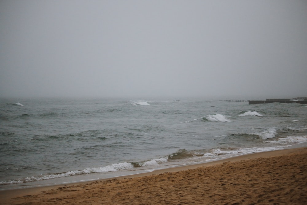 a sandy beach with waves coming in to shore