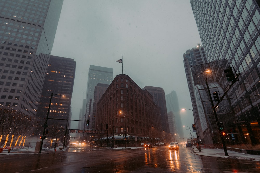 a city street with tall buildings on a rainy day