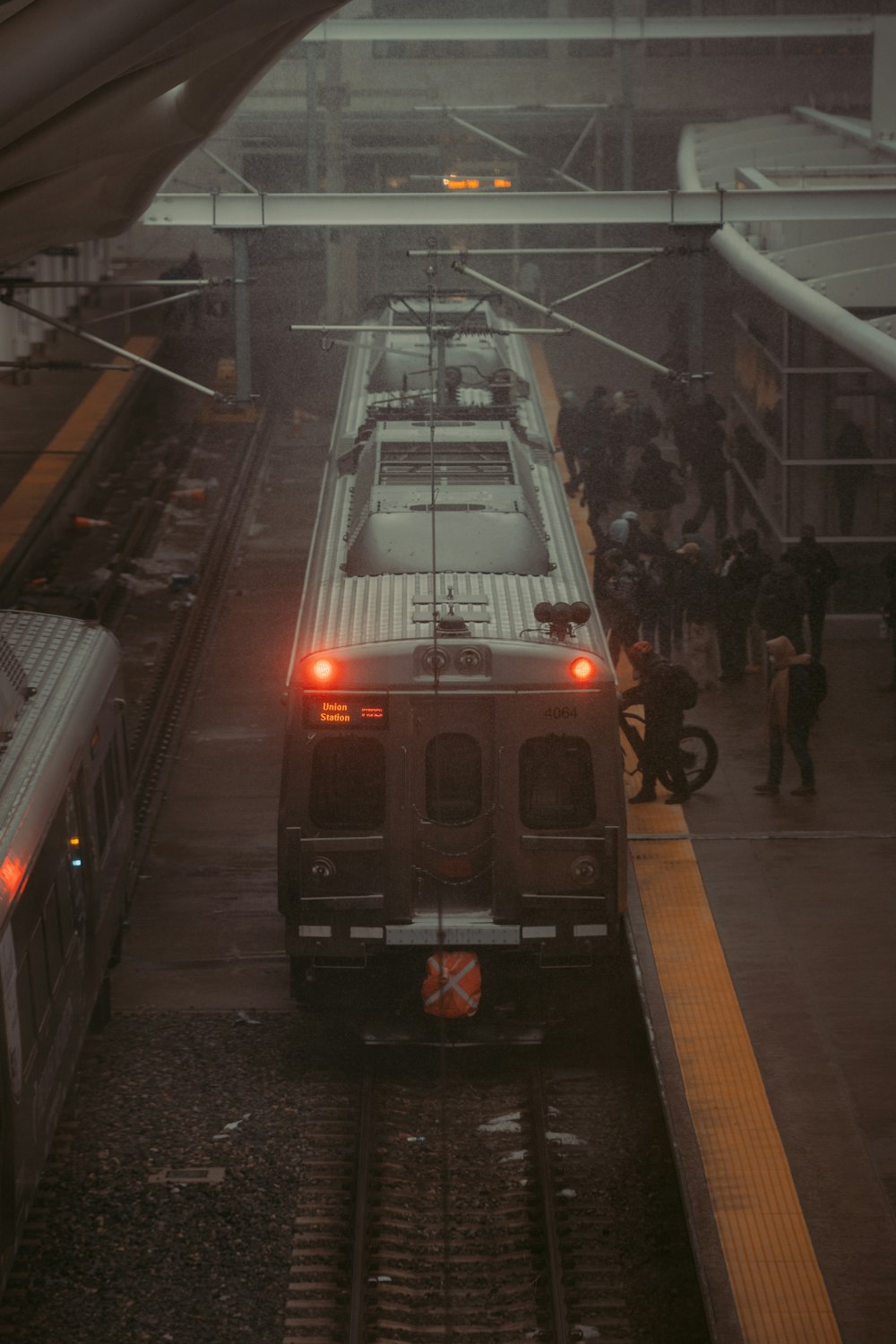 a train pulling into a train station in the rain