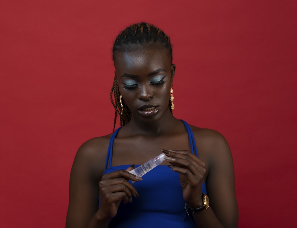 a woman in a blue dress looking at her cell phone