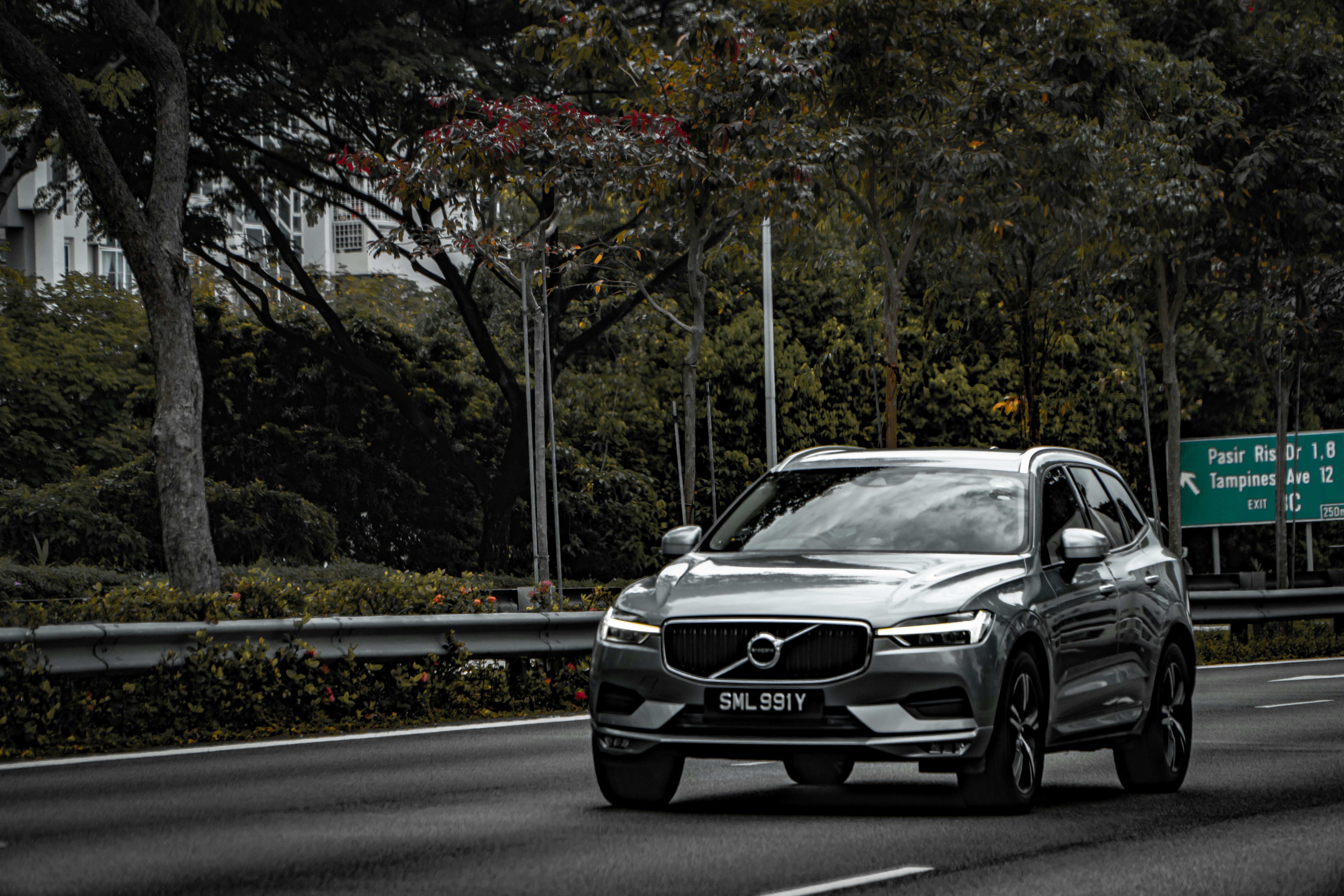 a silver volvo car driving down the road