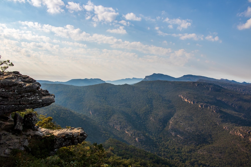 a view of a mountain range from a cliff