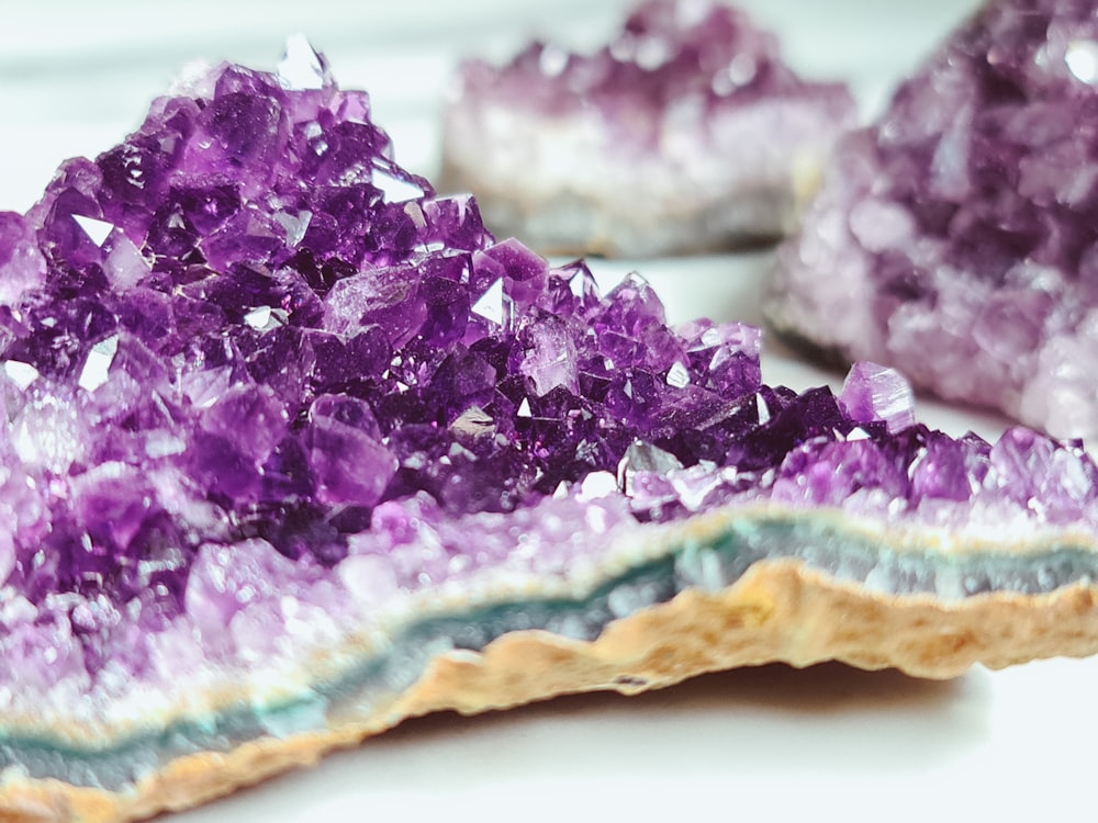 a close up of purple crystals on a white surface