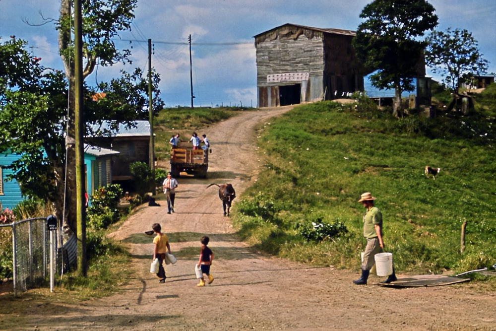 a group of people walking down a dirt road