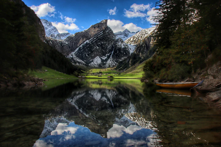 Swiss alpine lake framed by green slopes and snowy mountains