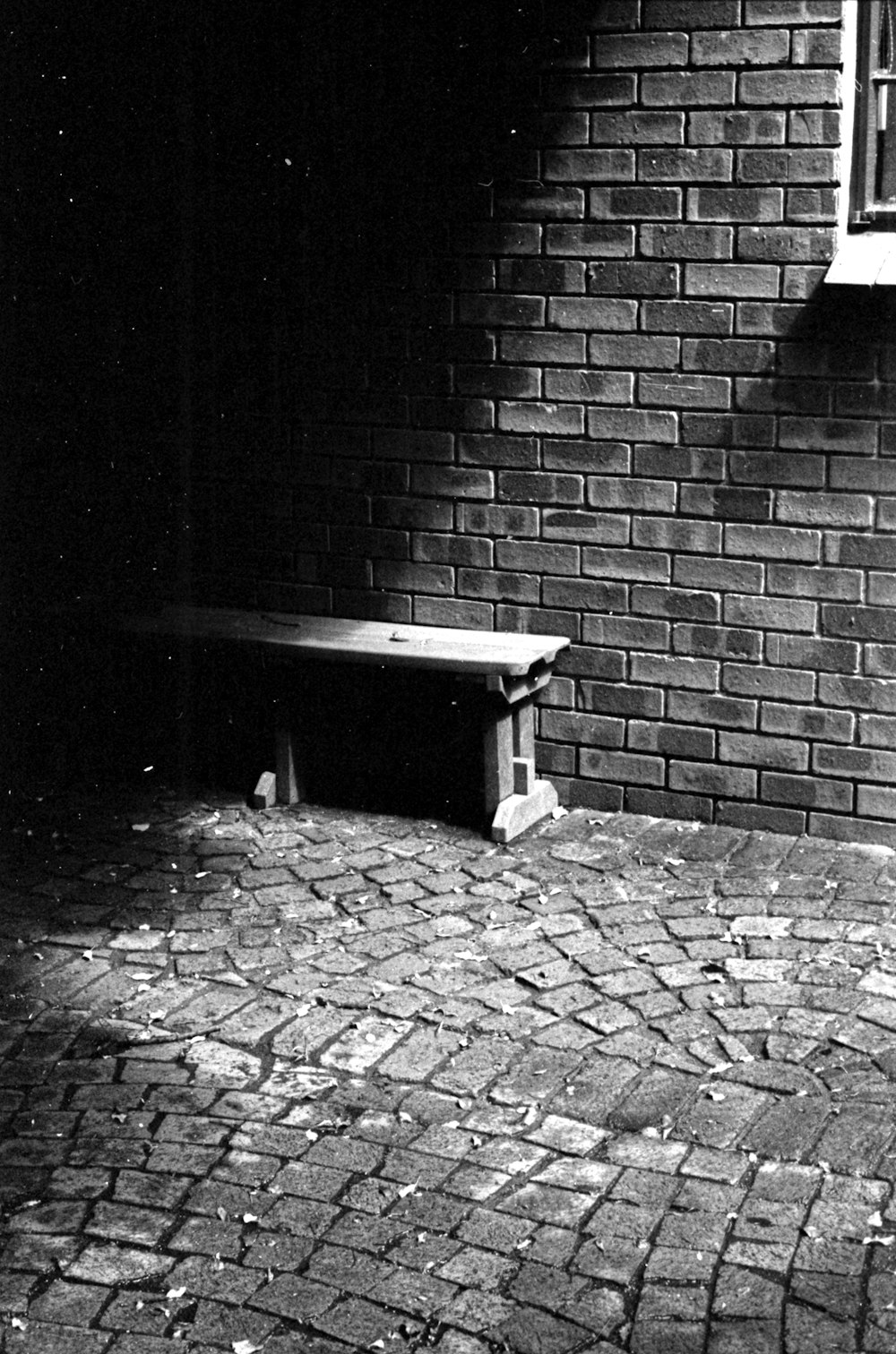 a stone bench sitting next to a brick wall