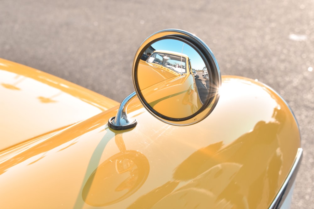 a rear view mirror on the side of a yellow car