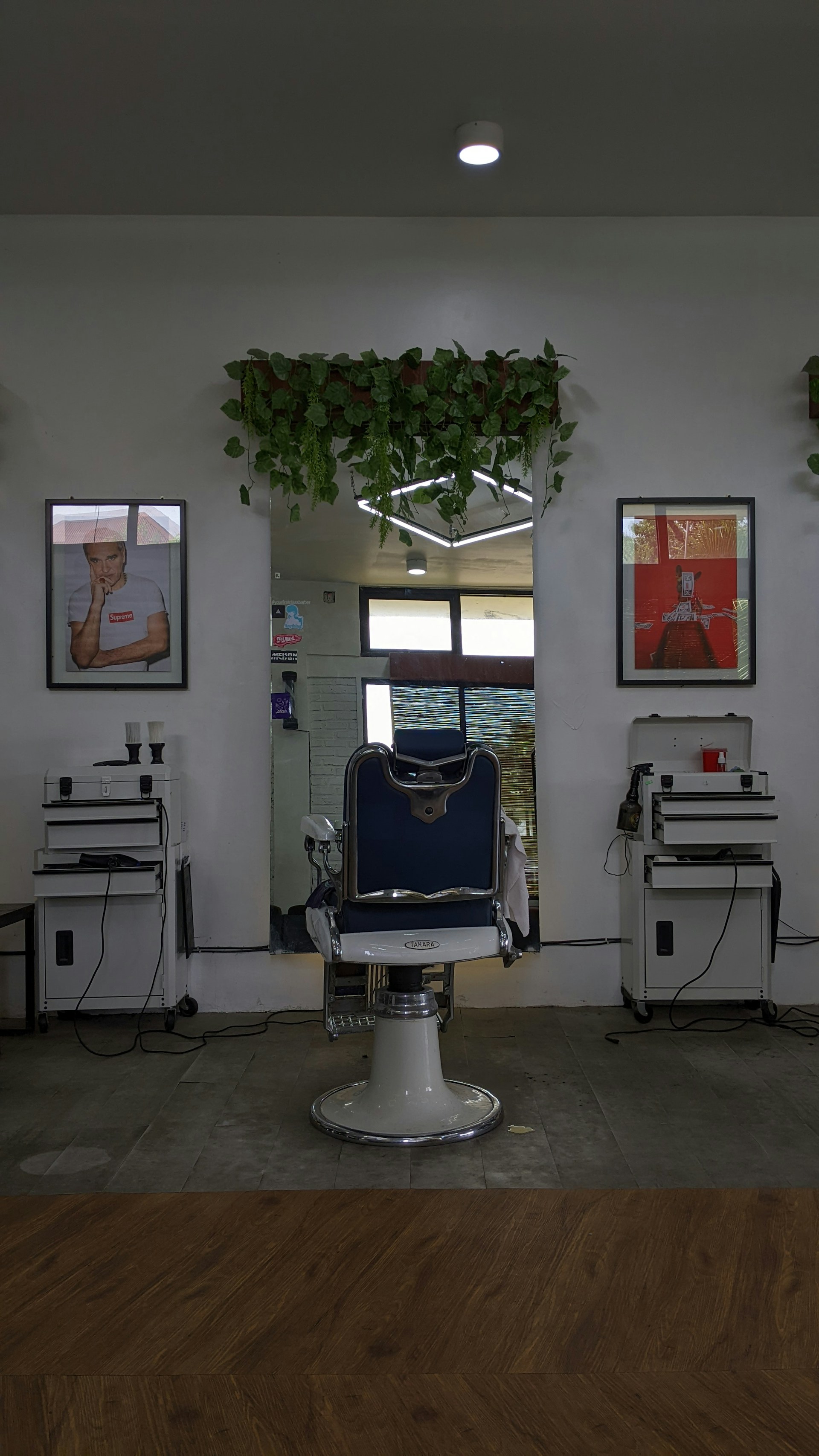 a barber chair in a room with two pictures on the wall
