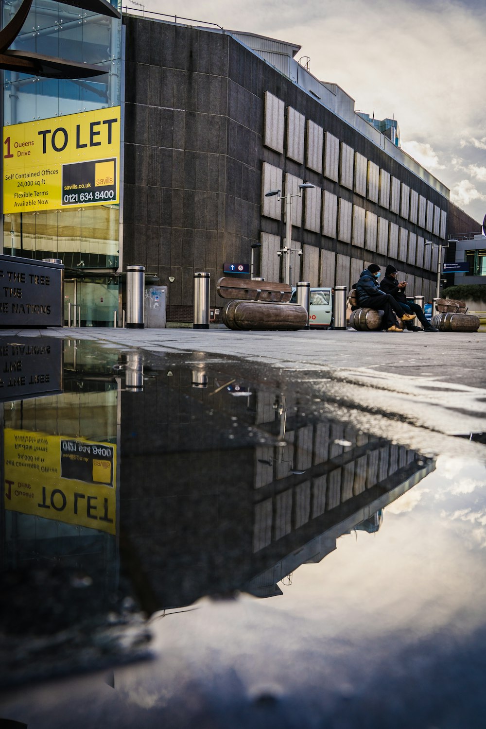 a person sitting on a bench in front of a building