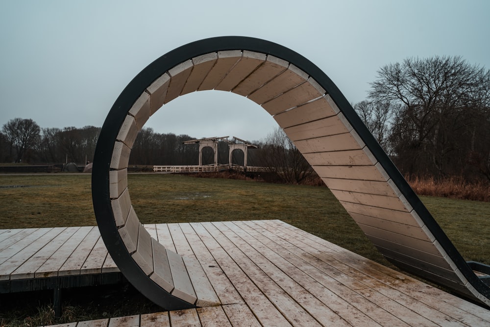 a curved bench sitting on top of a wooden deck