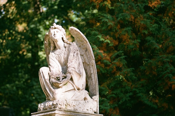 a statue of an angel sitting on a pedestal