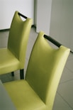 a pair of yellow chairs sitting on top of a tiled floor
