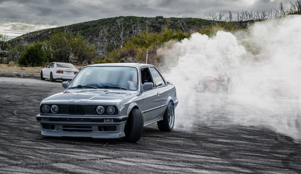 a silver car with smoke coming out of it