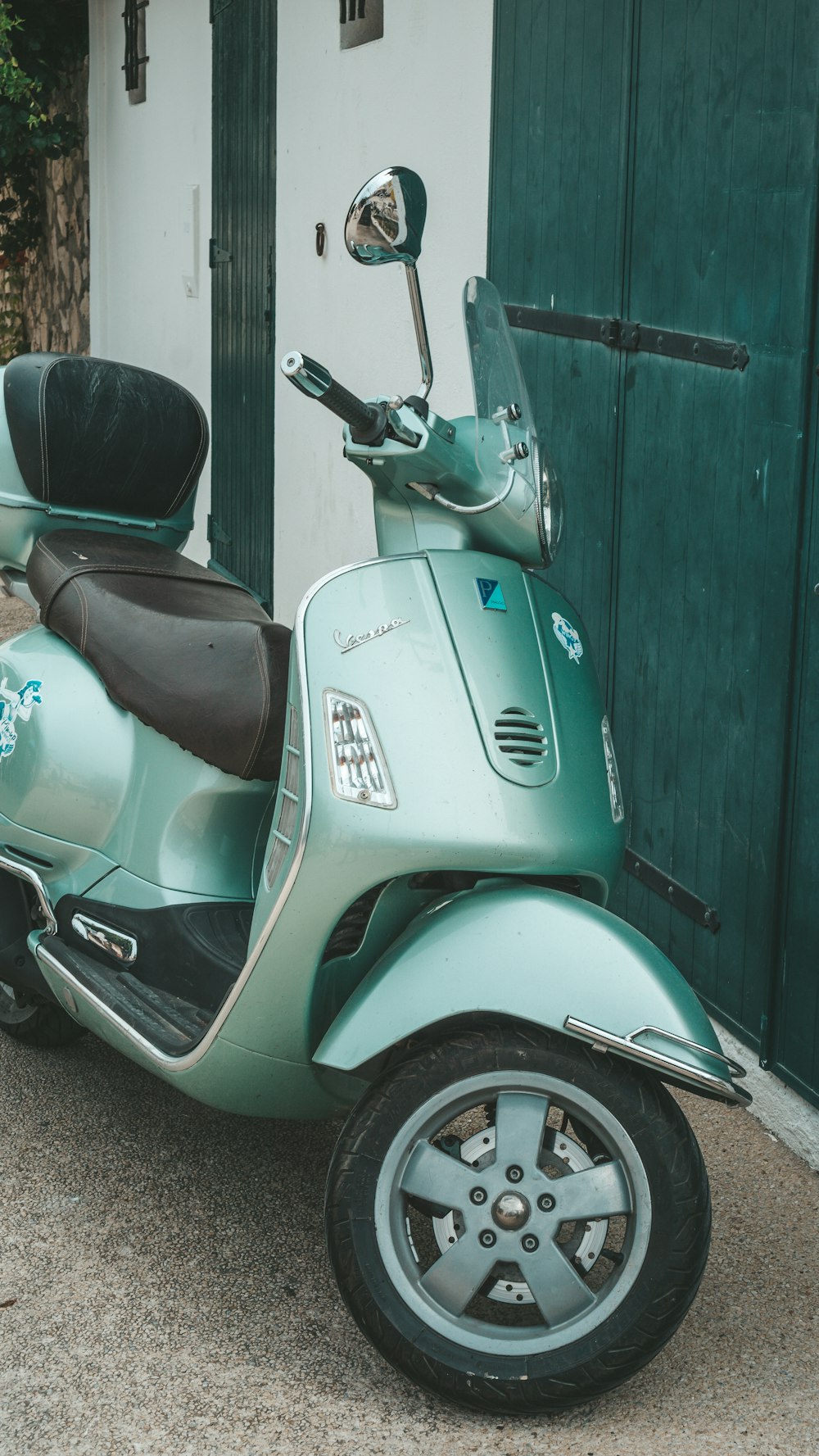 a green scooter parked in front of a building