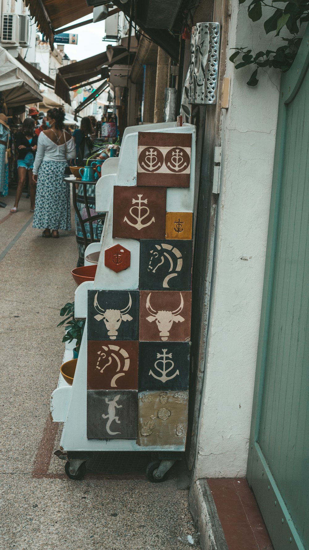 a street with people walking down it and a sign on the side of the road