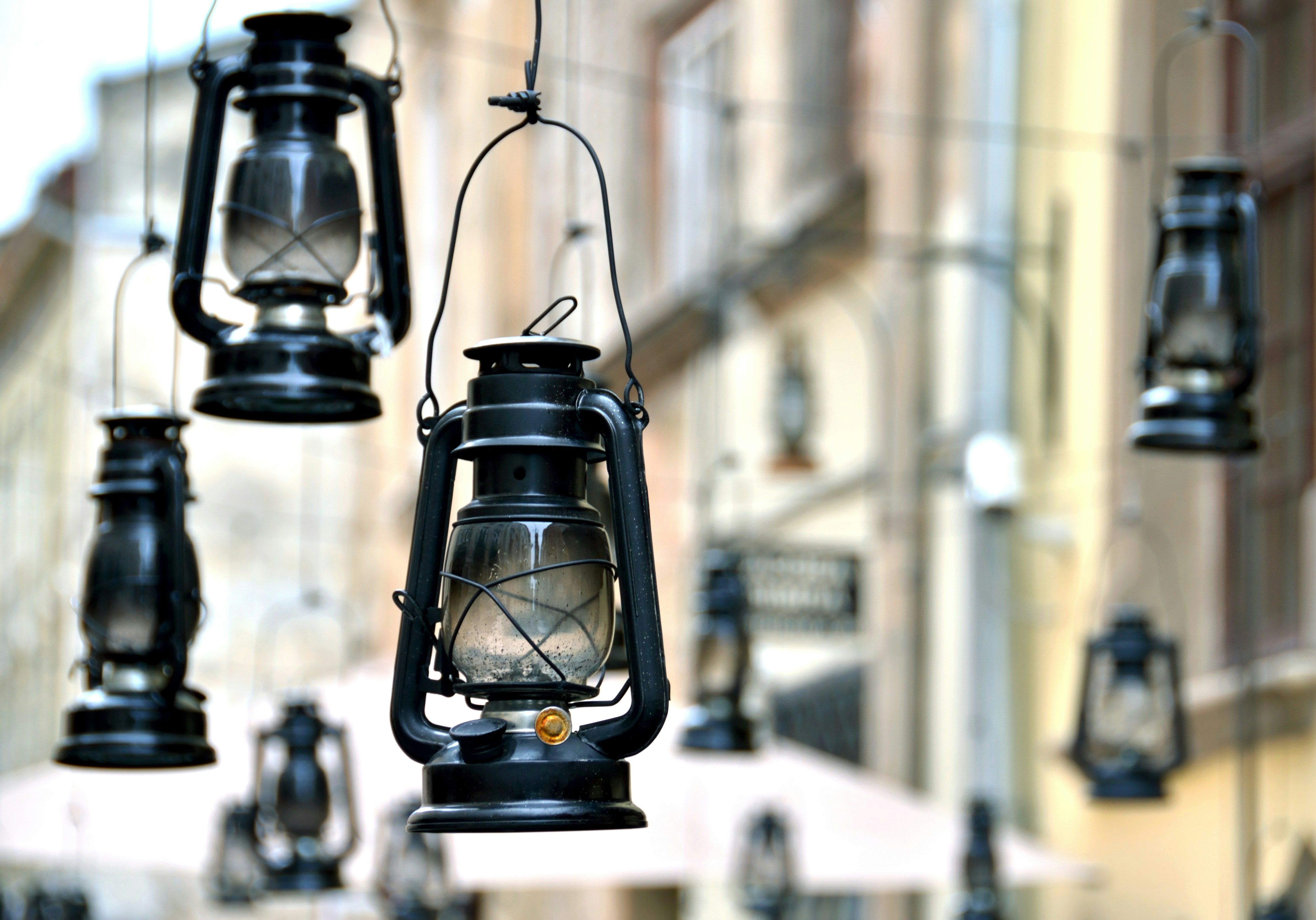 a group of black lanterns hanging from the side of a building