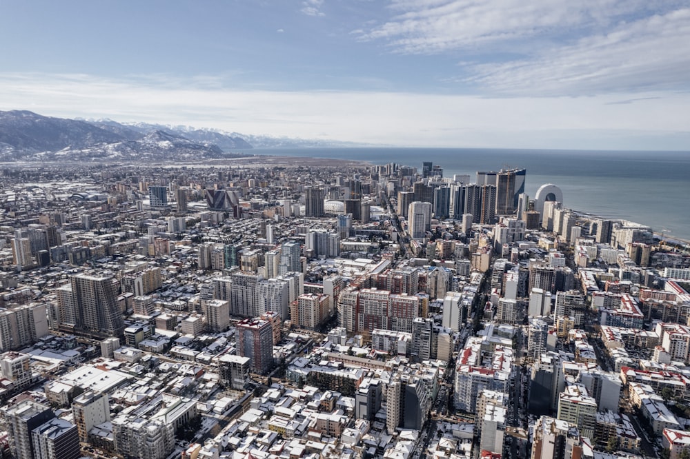 an aerial view of a large city with mountains in the background