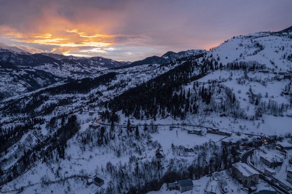 the sun is setting over a snowy mountain town