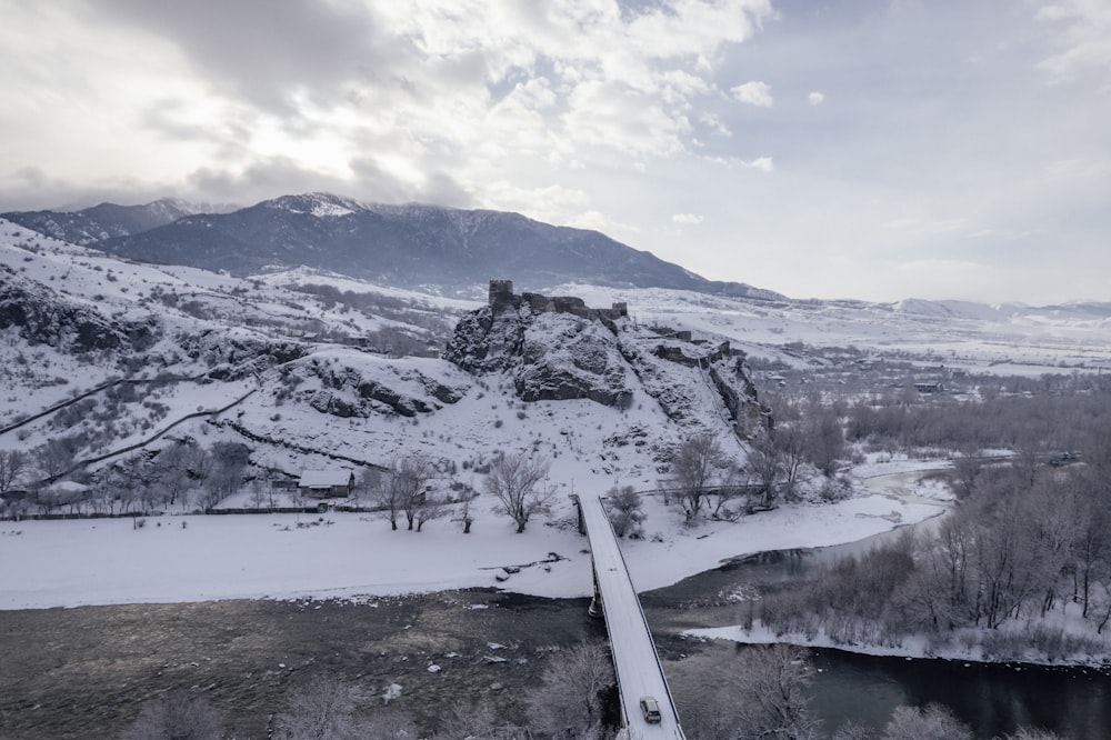 a snow covered mountain with a bridge going across it