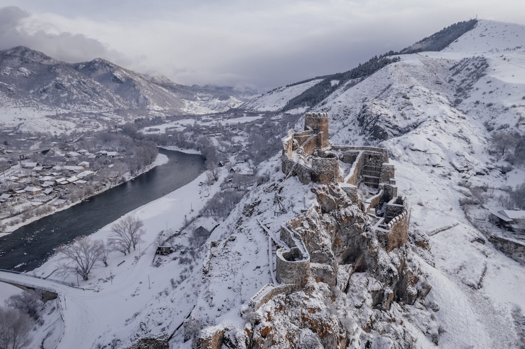 a snow covered mountain with a river running through it,